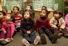 Pre-school students sitting on floor in classroom