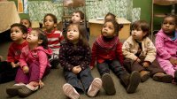 Pre-school students sitting on floor in classroom