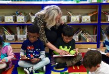 Teacher works with students on reading at Concourse Village.