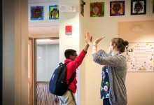 Teacher and student high-fiving, demonstrating proactive classroom management