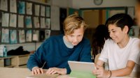 Two middle school students working together on a tablet